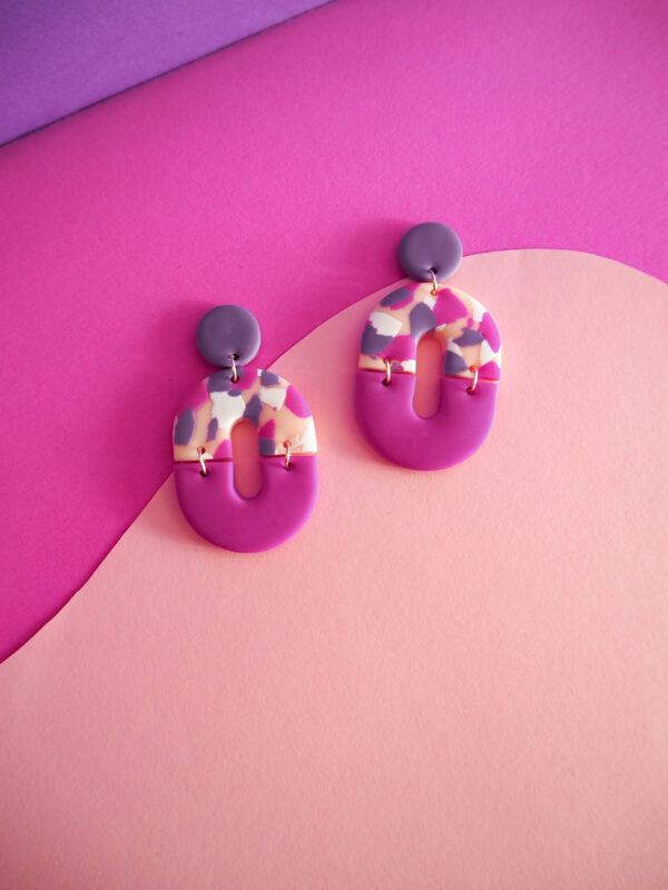 Boucles d'oreilles ovales avec une partie motif terrazzo rose, blanc, fuchsia et violet et une partie unie fuchsia