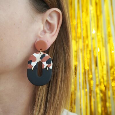 Boucles d'oreilles ovales avec une partie motif terrazzo beige, blanc, noir et terracotta et une partie unie noir