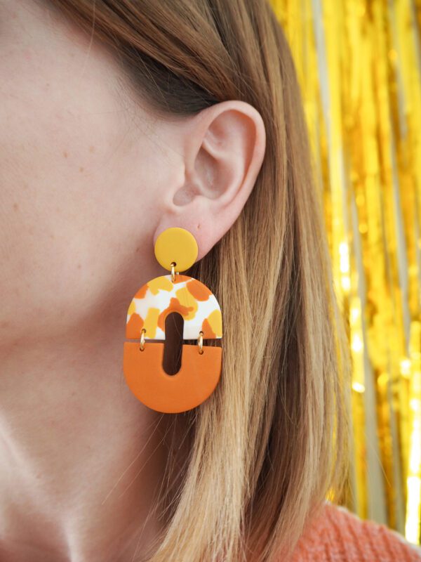 Boucles d'oreilles ovales avec une partie motif terrazzo blanc, rose, jaune et orange et une partie unie orange