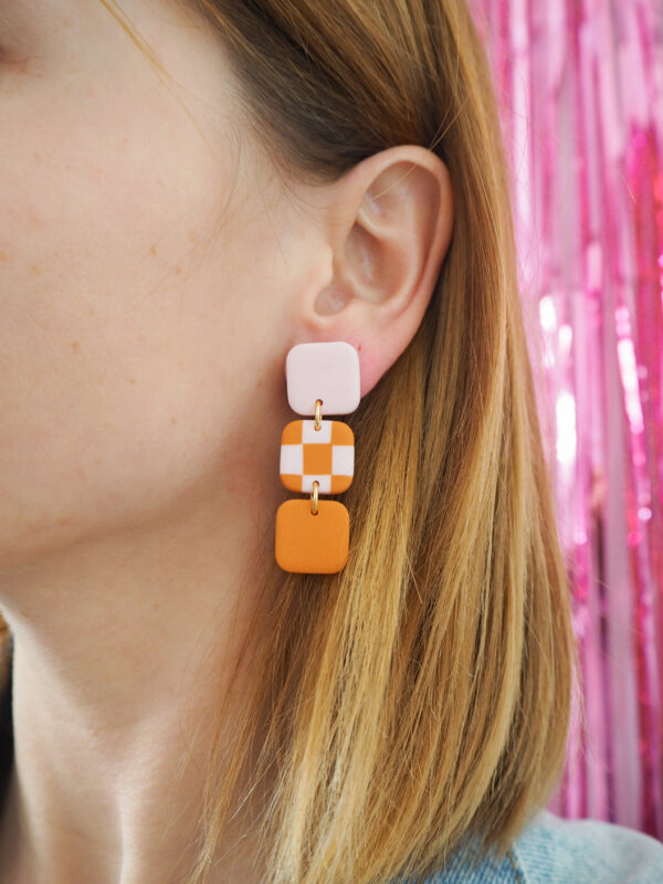 Boucles d'oreilles avec carré rose pale, carré motif damier rose pale et orange et carré orange