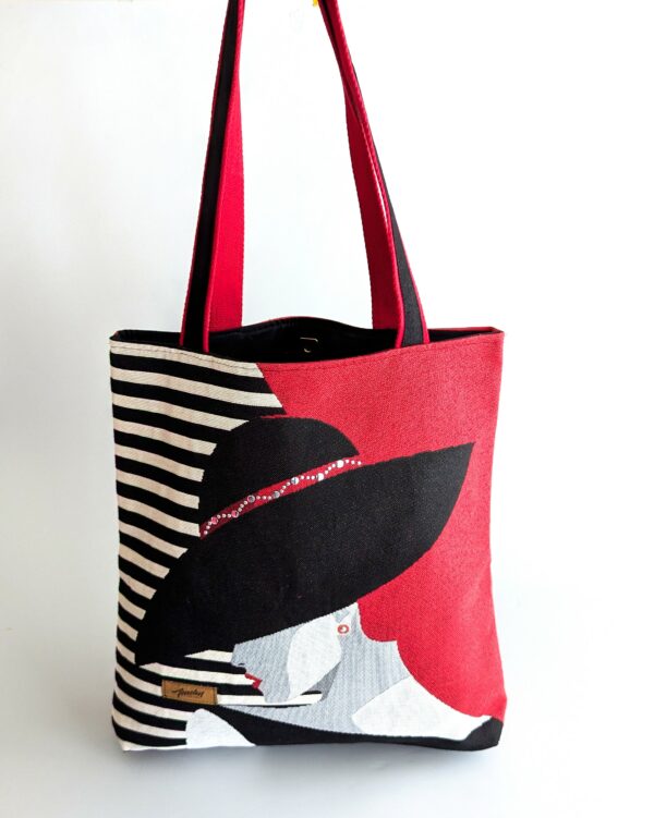 sac rouge et noir avec femme au chapeau noir