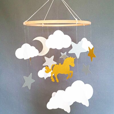 Mobile bébé fait main avec licorne dorée, nuages blancs et étoiles argentées suspendus à un cercle en bois naturel