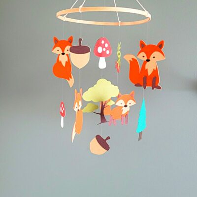 Quatre adorables petits renards, suspendus avec légèreté au-dessus du lit ou de la table à langer