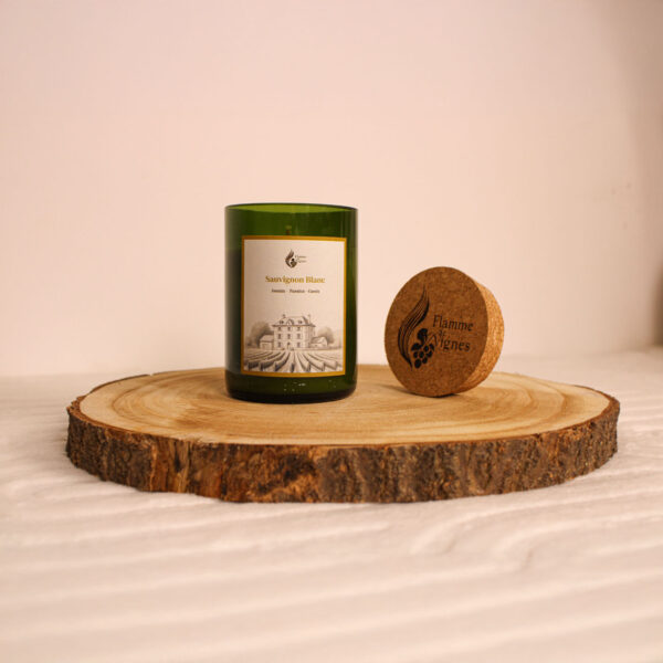 Bougie parfumée artisanale faite main – posée sur un lit en tissu blanc