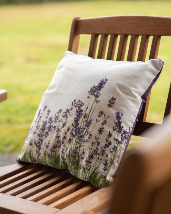 Coussin en issu écru avec fleurs de lavande posé sur une chaise en bois