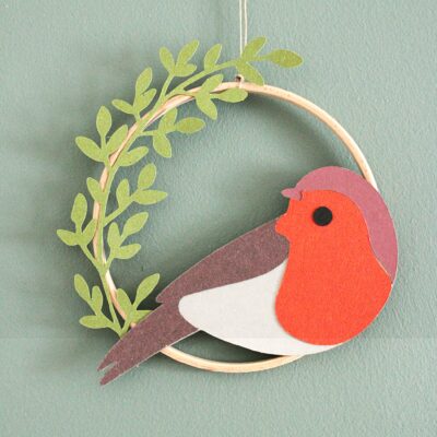 Décoration murale faite main avec oiseau en papier et feuillages dans un cercle en bois