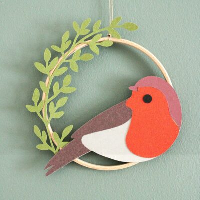 Décoration murale faite main avec oiseau en papier et feuillages dans un cercle en bois