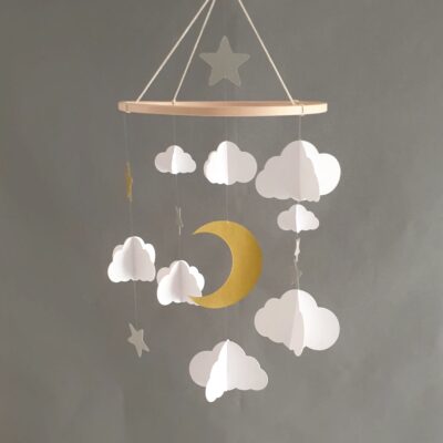Suspension décorative en papier sur le thème du ciel étoilé, avec une lune dorée et des nuages légers.