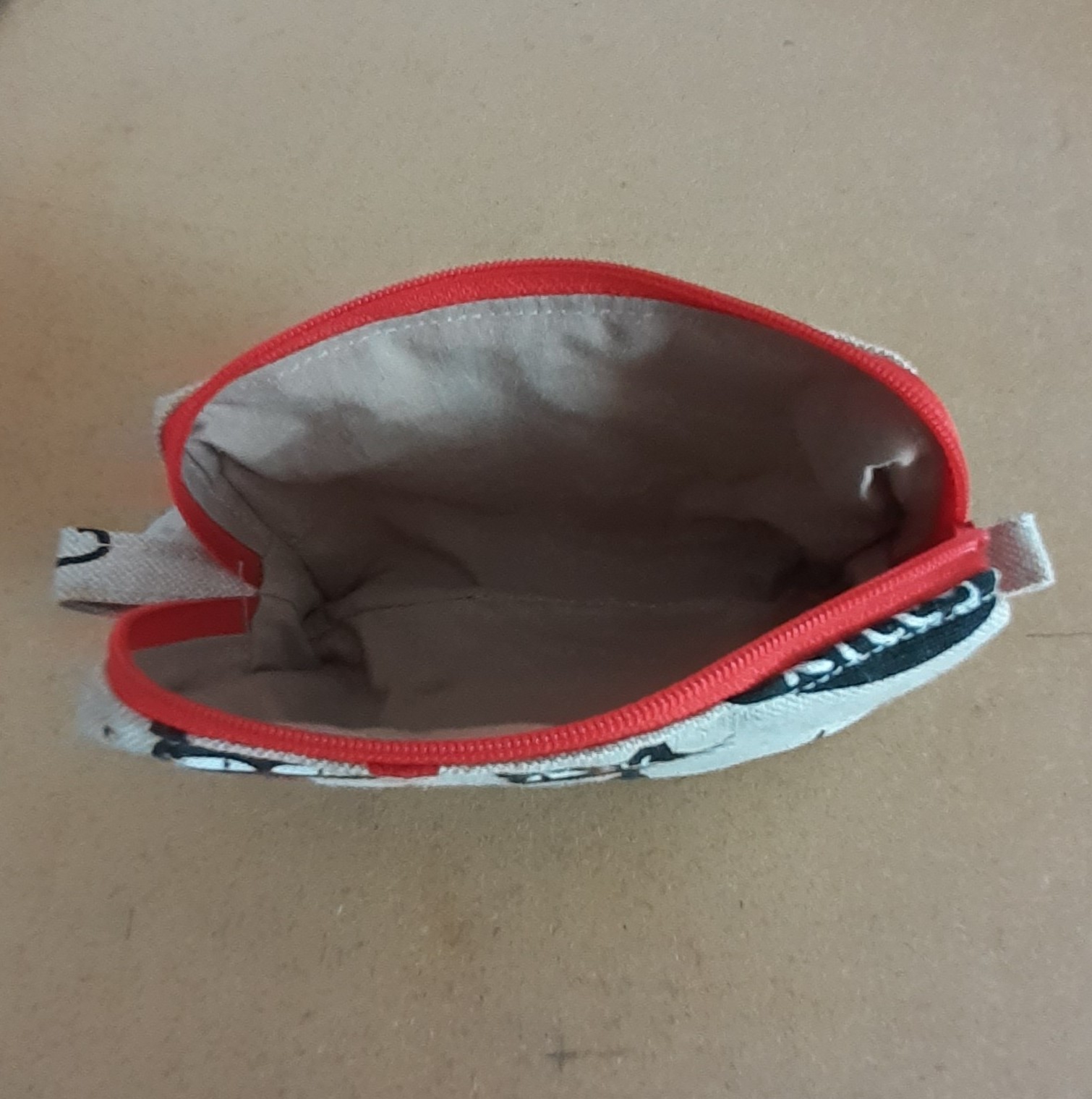 "mini trousse ouverte et montrant l'intérieur et sa doublure taupe"