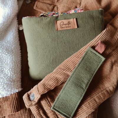 Pochette vert forêt et marque page enveloppés dans une veste en velours