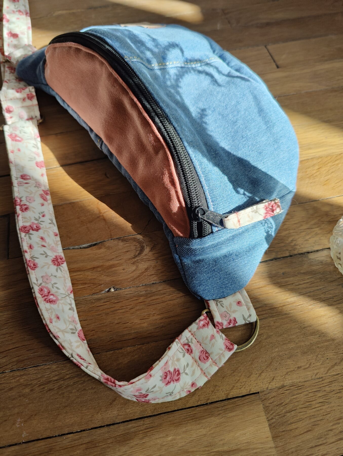 Sac banane jean bleu Hollister upcyclé. Intérieur roses délicates. Détails zip et sangle assortie