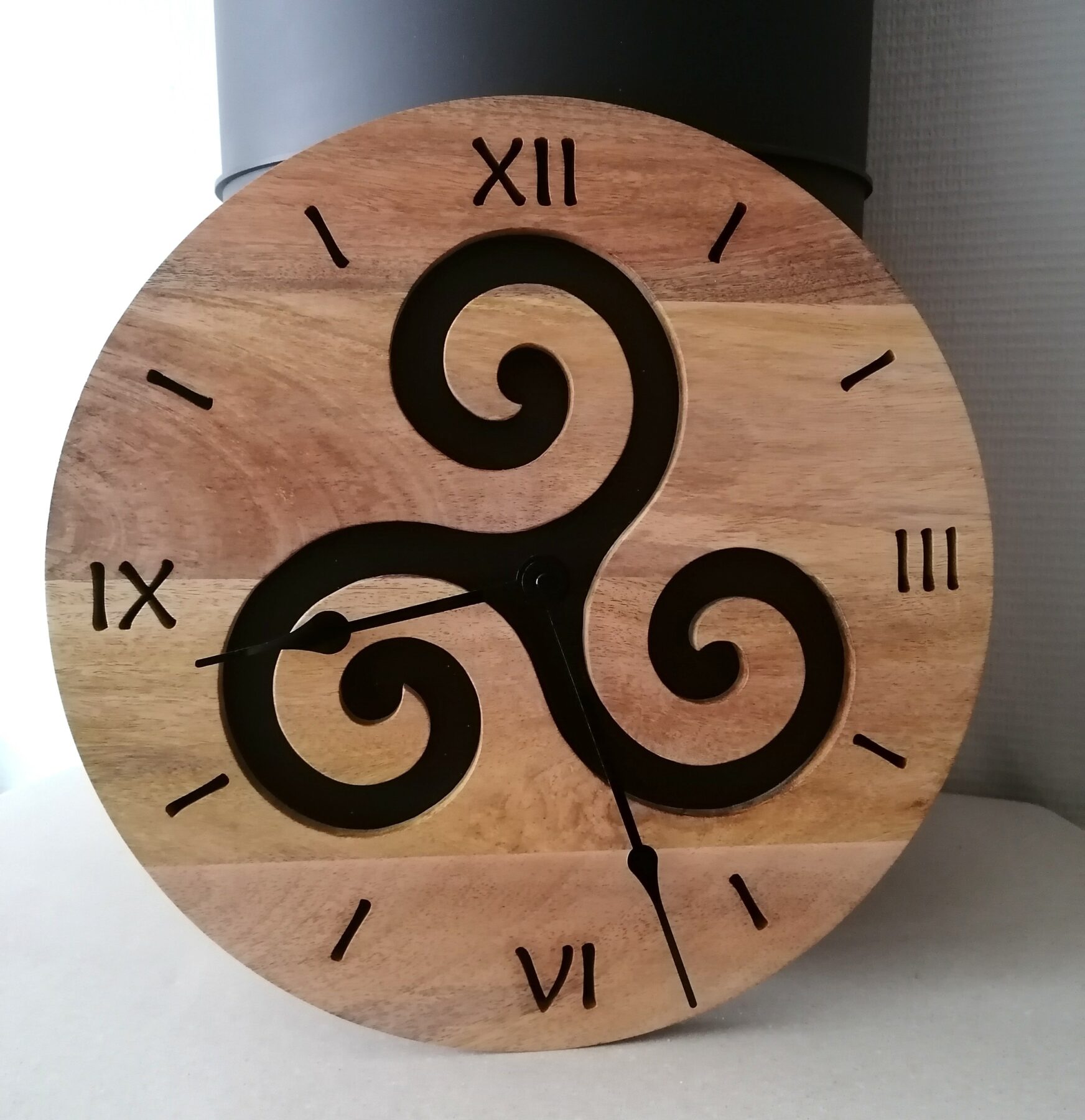 Horloge murale en bois massif, motif triskèle fait mains, pour sublimer votre intérieur dans un environnement naturel, serein et unique.