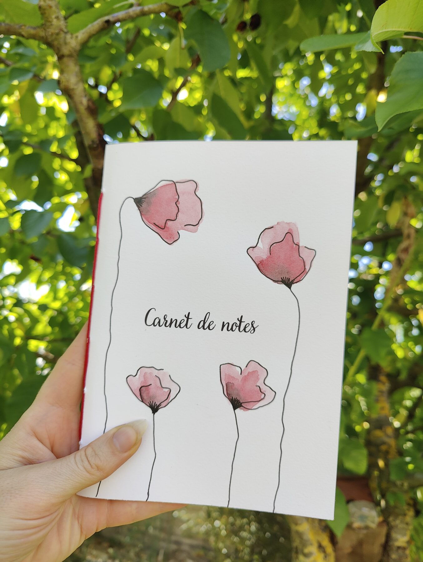 Carnet de notes format A5 tenu dans la main