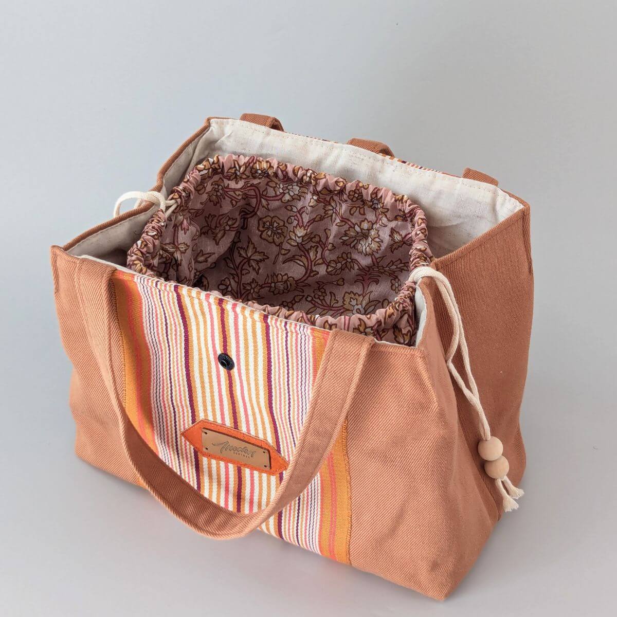 Intérieur du sac montrant son pochon en toile fleurie avec son cordon de fermeture