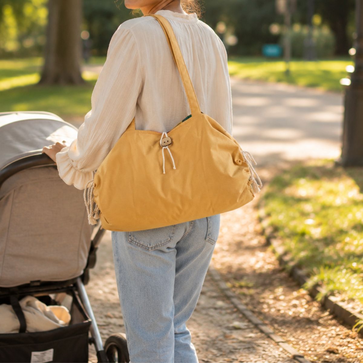 Le Tapis de change nomade bébé porté à l'épaule d'une maman