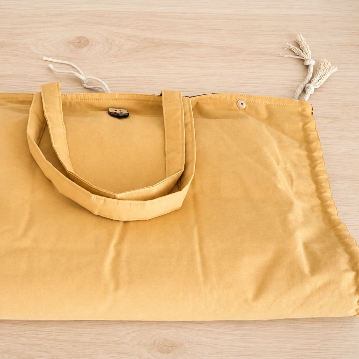 Le tapis à langer jaune, plié en deux posé sur une table