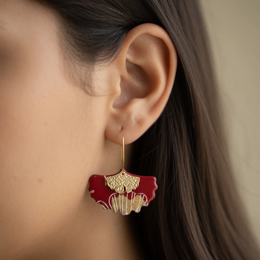 Boucles d'oreilles créoles Gingko rouge et or portées à l'oreille