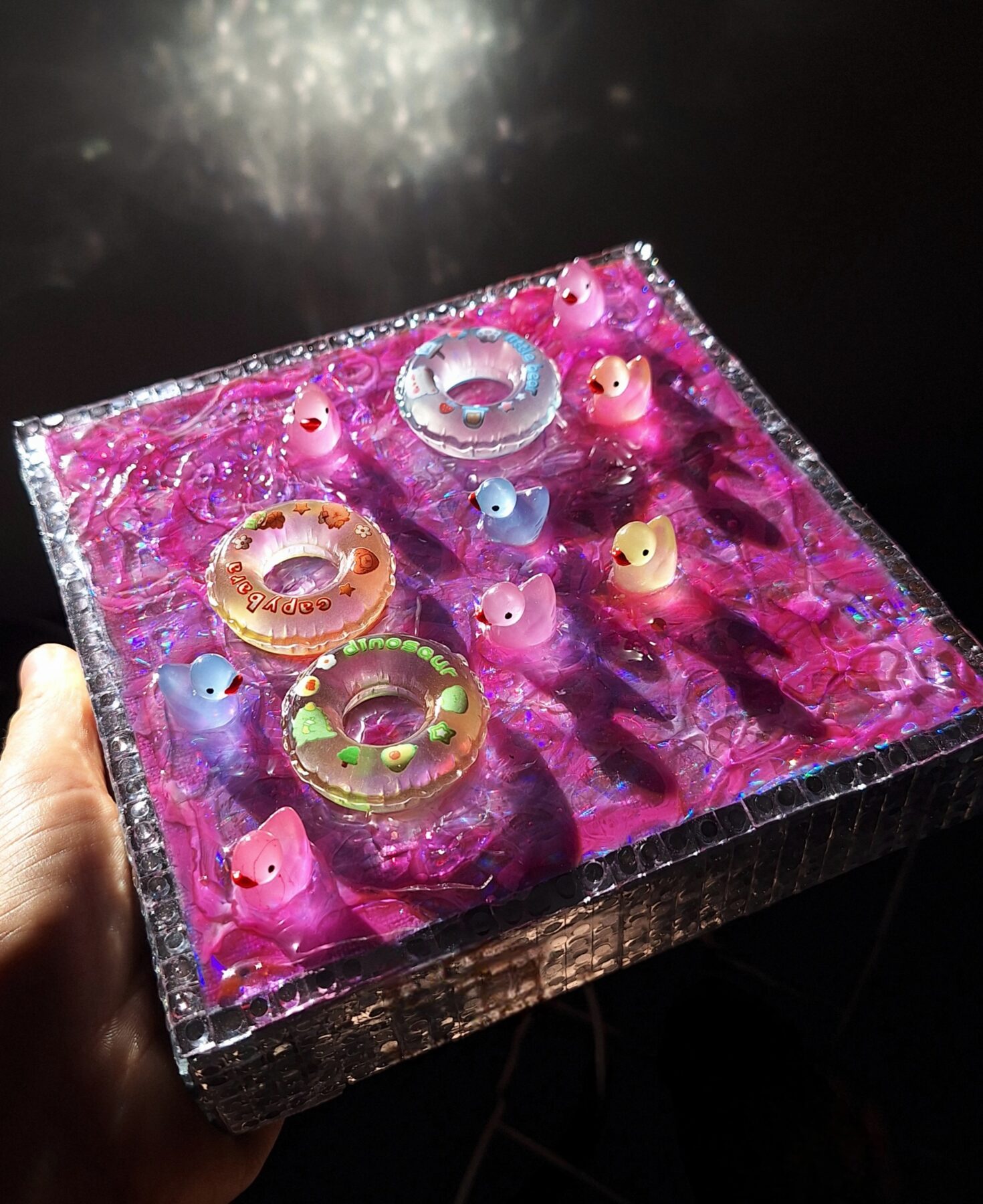 Tableau décoratif 3D fait main représentant une piscine avec de l'eau rose et des bouées.