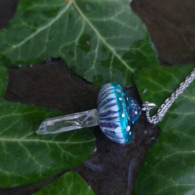 Pendentif en forme de champignon avec pied en cristal de roche naturel. Pendentif 3x5 cm, chaîne 45 cm. Quartz naturel, pâte polymère, résine d'époxy. Bleu vert, bleu lagon, bleu canard, transparent. Soigneusement emballé dans une boîte cadeau prête à offrir. Fluorescent réactif à la lumière UV néon, phosphorescent lumineux dans le noir. Féerique, forêt, cottagecore, fairycore, boho, psychédélique, witchy, kawaii, mignon, fantastique, champêtre.