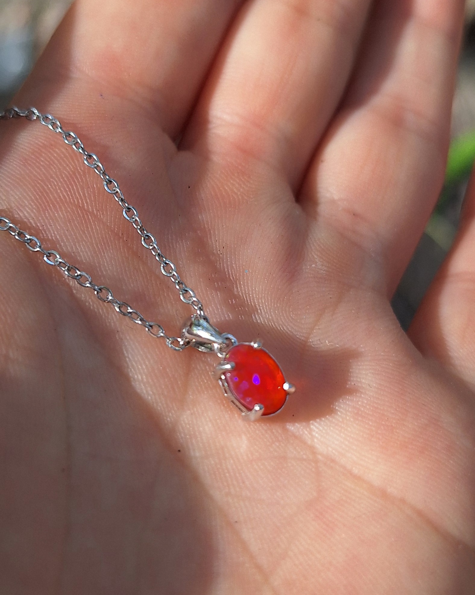 Magnifique pendentif composé d'une opale de feu naturelle aux nuances intenses, sertie sur une monture en argent et accompagnée d'une chaîne solide en acier inoxydable. 6 x 8 mm pour la pierre, 45 cm pour la longueur de la chaîne. Argent, opale de feu naturelle, acier inoxydable. Rouge, orange vibrant, avec des reflets fluorescents et violacés sous la lumière. Livré dans une élégante boîte cadeau prête à offrir, accompagnée d'un petit cadeau surprise. La pierre offre un superbe jeu de lumière et des reflets chatoyants uniques sous chaque angle. Le bijou est hypoallergénique, durable et résistant pour un confort quotidien. Boho chic, féerique, céleste, élégant, witchy, mystique, minimaliste raffiné